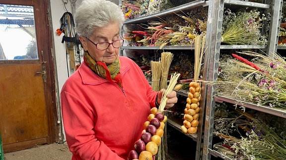 Eine Frau präsentiert einen Zwiebelzopf.