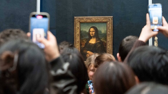 Besucher fotografieren in Paris, Frankreich, mit ihren Handys das Gemälde von Mona Lisa im Louvre.