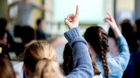 Schülerinnen melden sich während des Unterrichts an einer Schule.