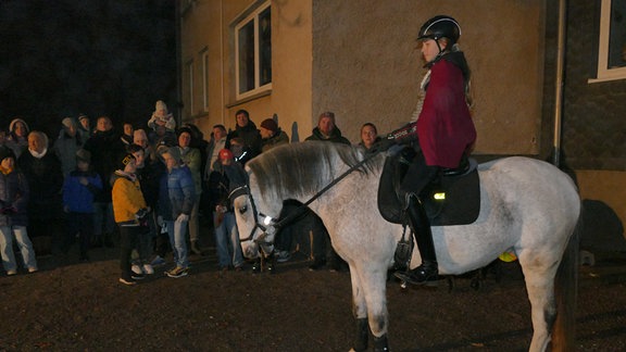 Ein Kind als St. Martin verkleidet auf einem Pferd.