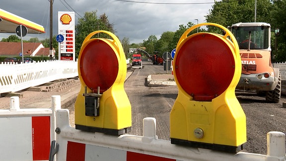 Auf einer gesperrten Straße wird der Asphalt abgefräst.