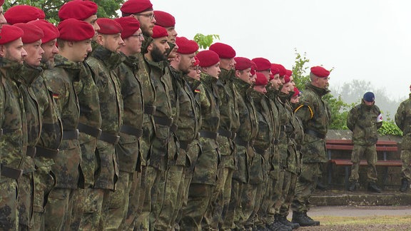 Bundeswehrsoldaten stehen in Reih und Glied auf einem Platz.