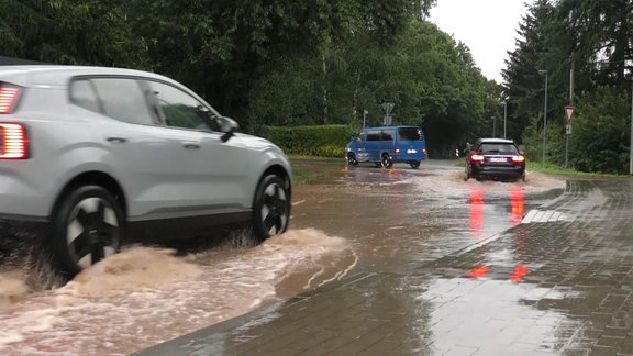 Drei Auto fahren auf einer überfluteten Straße