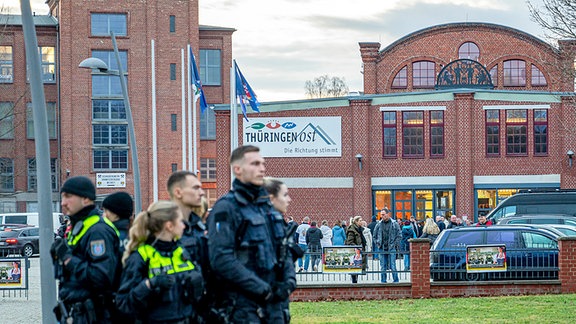 Polizisten vor einer großen Halle