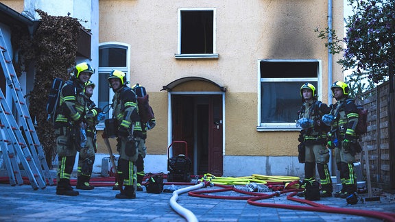 Feuerwehrleute löschen einen Brand in einem Wohnhaus in Gera