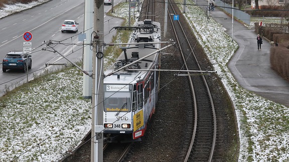 Eine Straßenbahn fährt 2021 durch das Wohngebiet Lusan.