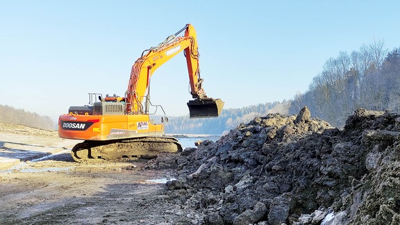 Ein Bagger schaufelt gefrorene Erde