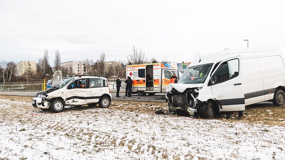 Unfallstelle mit Einsatzkräften- und fahrzeugen sowie demolierten Fahrzeugen