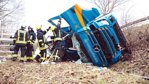 Feuerwehrleute an verunfalltem Lkw