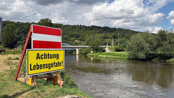 Achtung Lebensgefahr! steht auf einem auffälligem Schild am Ufer der Saale.