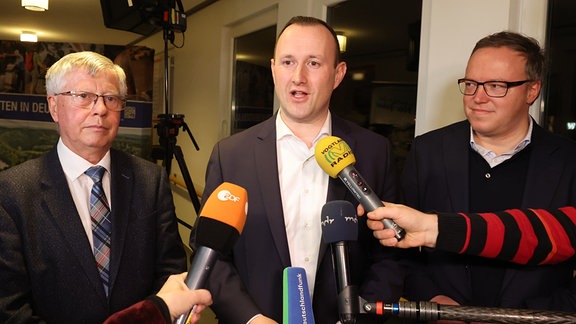 Thomas Fühmann (l-r, CDU), scheidender Landrat, Christian Herrgott (CDU), Wahlsieger, und Mario Voigt, CDU-Vorsitzender in Thüringen vor Mikrofonen