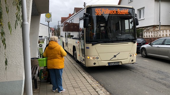 Ein Bus hält in einem Dorf an der Haltestelle