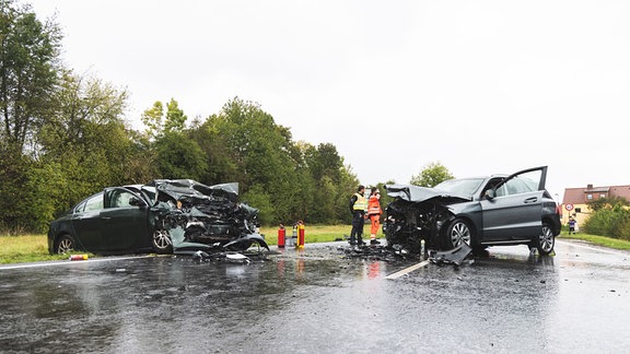 Unfallstelle mit schwer beschädigten Fahrzeugen und Einsatzkräften