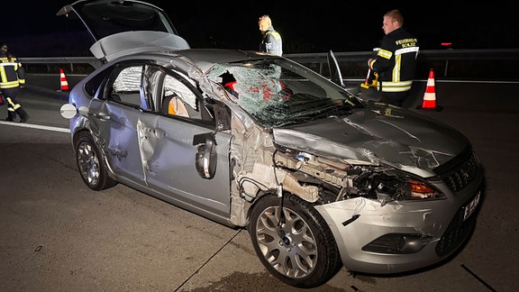 Feuerwehr und Polizei stehen um das Auto.