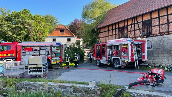 Ein zerstörtes Wohnhaus, davor Rettungseinsätze.