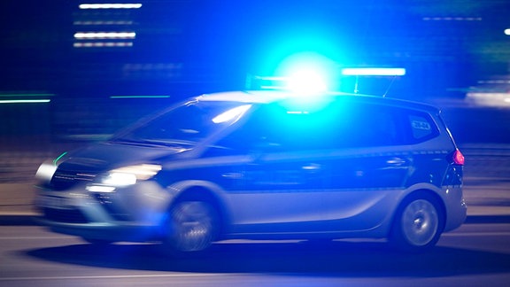 Ein Polizeiauto bei einer Einsatzfahrt mit Blaulicht.