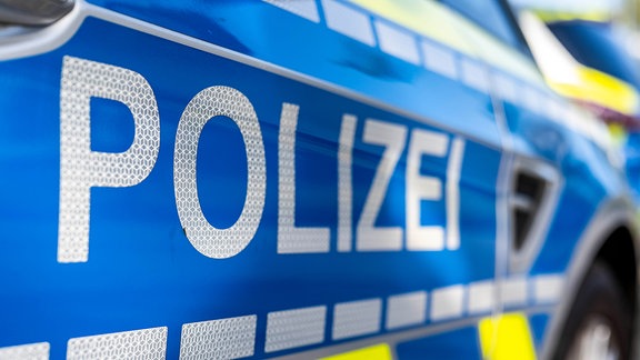 An der Tür von einem Streifenwagen steht der Schriftzug Polizei