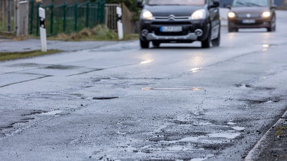 Schlagloch auf einer kaputten Straße