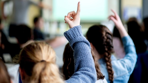 Schülerinnen melden sich während des Unterrichts an einer Schule. 