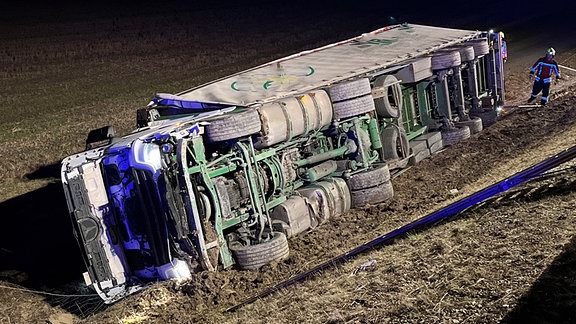 Ein verunglückter Lkw-Sattelzug liegt auf der Seite.