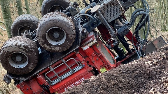 Ein umgestürzter Forsttechnik-Anhänger im Wald.