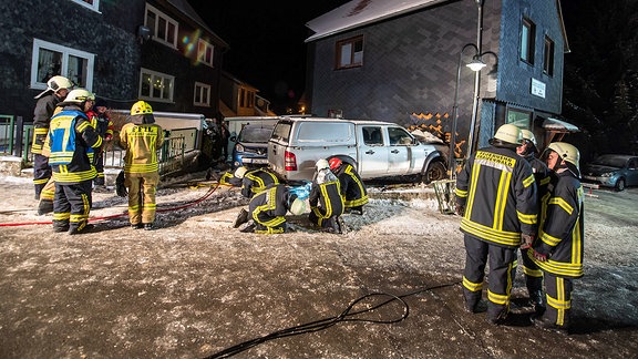 Ein Auto ist in eine Hauswand gefahren, drum herum stehen Feuerwehrmänner.