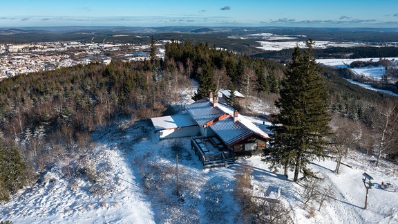 Die Bobhütte auf dem Lindenberg liegt zwischen schneebedeckten Bäumen im UNESCO-Biosphärenreservat Thüringer Wald.