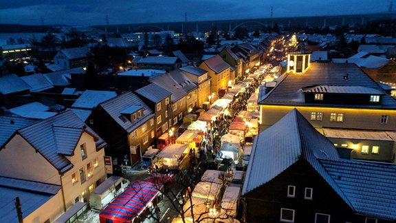 Ein Weihnachtsmarkt erleuchtet einen ansonsten im Dunkeln liegenden Ort.