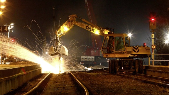 Gleisbauarbeiter wechseln in der Nacht eine Weiche im Bahnhof Zella Mehlis in Thueringen aus . Hier durchtrennt ein Arbeiter eine Schiene mit einer Flex. 