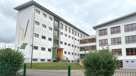 Die Regelschule Kaltennordheim mit Pausenhof im Herbst von außen.