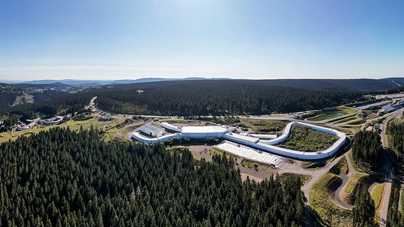 Ein langgezogenes Gebäude umgeben von Wald.