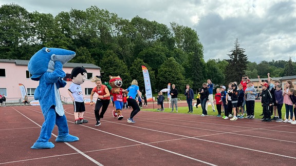 Kinder auf einem Sportplatz.