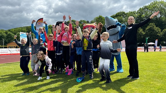 Kinder auf einem Sportplatz.