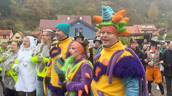 Als Aliens und Eisbären verkleidete Menschen schunkeln in einer Reihe.