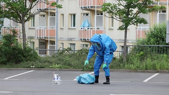 Ein Mann in Schutzausrüstung untersucht ein weißes Pulver