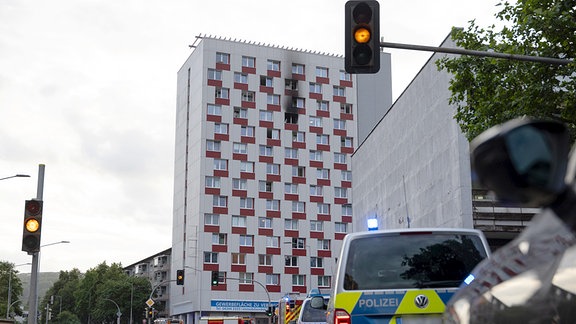 Ein verrauchter Bereich an einem Hochhaus, im Vordergrund Einsatzfahrzeuge