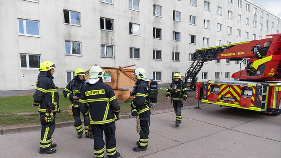 Feuerwehr vor einem hellen Gebäude (Plattenbau)