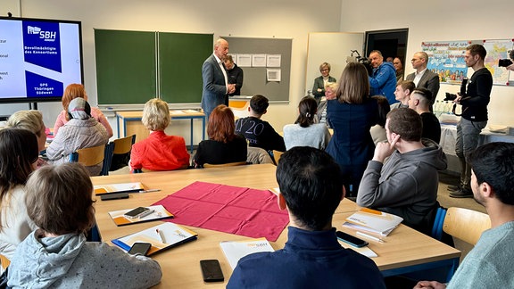 Wirtschaftsminister Tiefensee steht in einem Klassenraum.