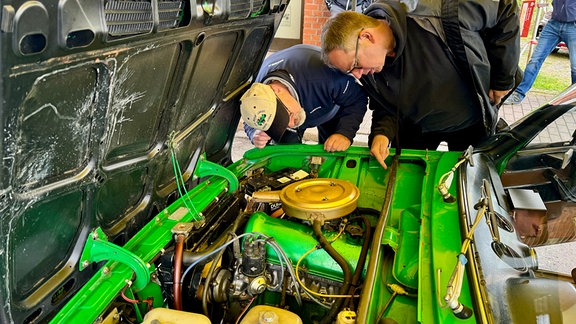 Technische Abnahme zur 60. Rallye Wartburg Eisenach: Zwei Männer blicken in einen Motorraum.