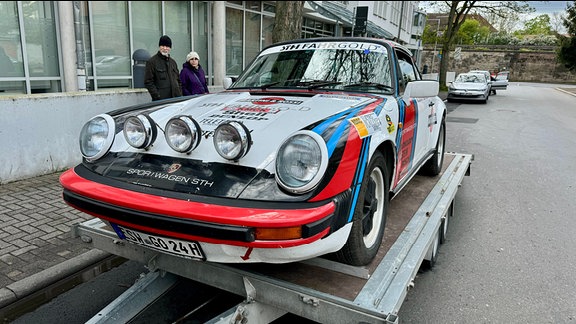 Technische Abnahme zur 60. Rallye Wartburg Eisenach: Renn-PKW auf einem Anhänger.