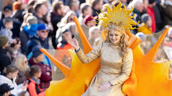 Frau Sunna grüßt beim Festumzug zum  Sommergewinn die Zuschauer.