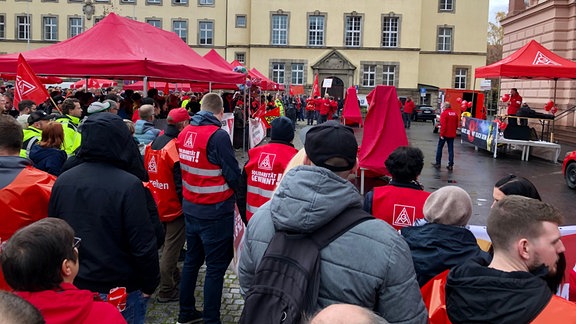 Viele Menschen streiken auf einem Platz.