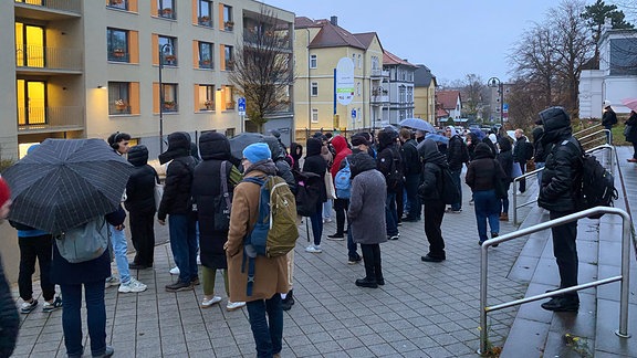 Menschen in der Dämmerung an Bushaltestelle