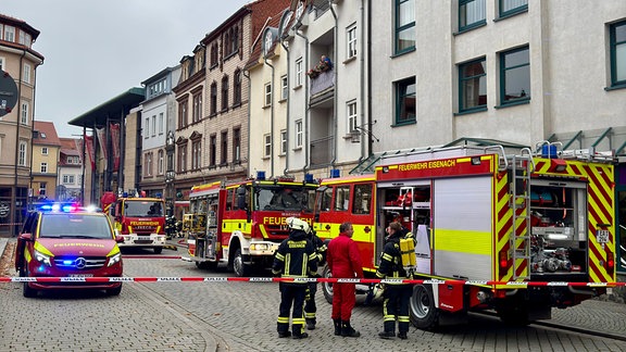 Mehrere Feuerwehrautos und Absperrband vor einem Haus in Eisenach