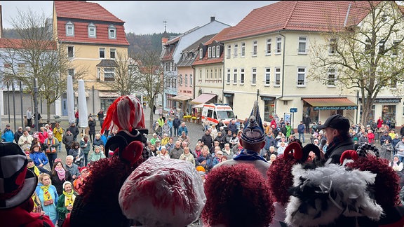 Karneval Bad Salzungen: Karneval-Leute von hinten blicken auf die Menschenmenge auf dem Hildburghäuser Marktplatz