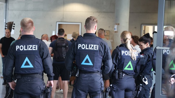 Polizeibeamte stehen vor dem Verhandlungssaal.