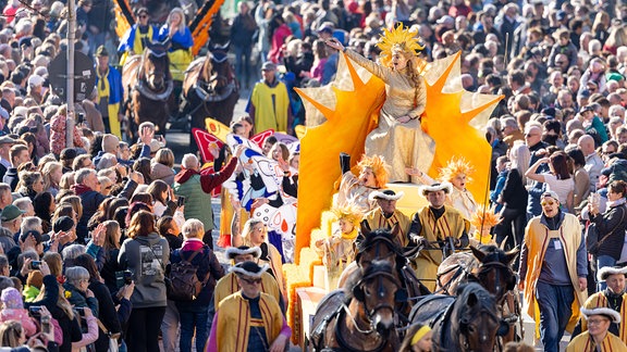 Frau Sunna grüßt beim Festumzug zum  Sommergewinn die Zuschauer.