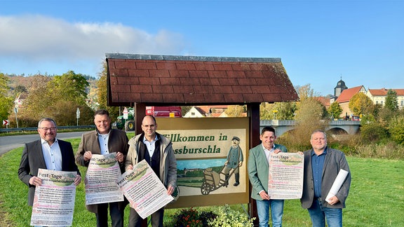 Menschen vor einem Ortseingang