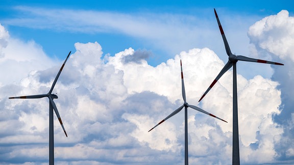 Wolken türmen sich über Windrädern