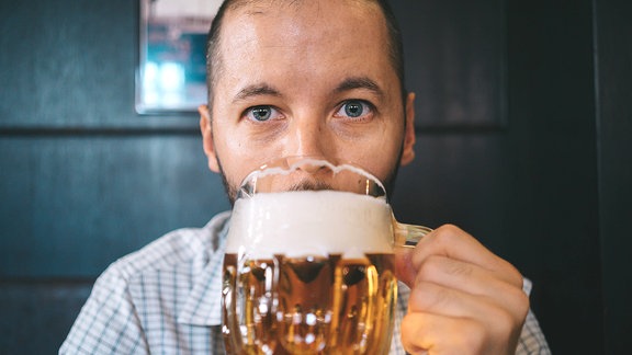 Ein Mann trinkt aus einem Bierglas